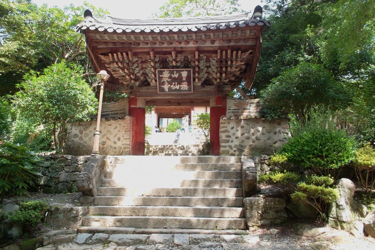 The open wooden doors in front of a temple in Korea on a sunny day