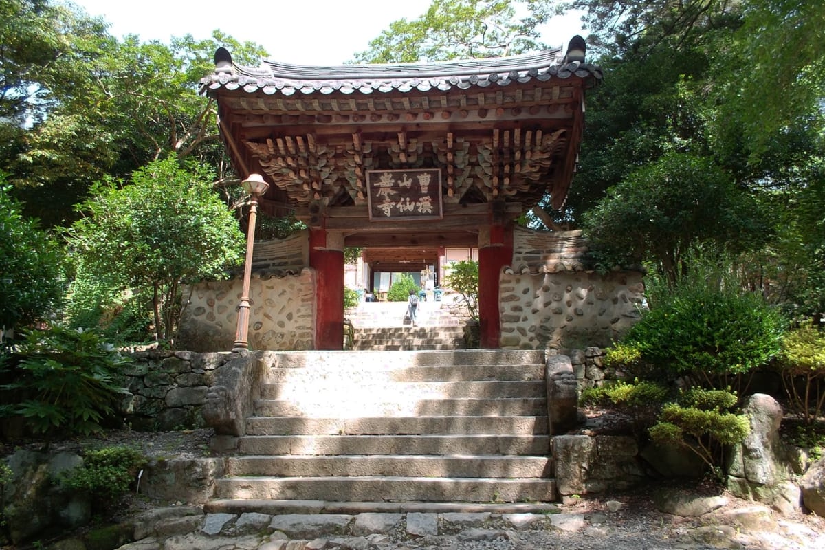 The open wooden doors in front of a temple in Korea on a sunny day